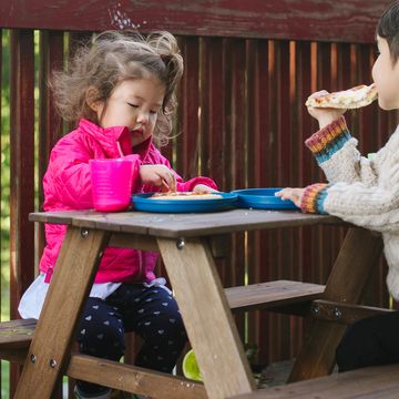 young kids eating at a kids picnic table on deck