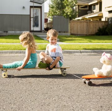 niños en monopatin jugando en la calle