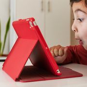kid playing with tablet in red case
