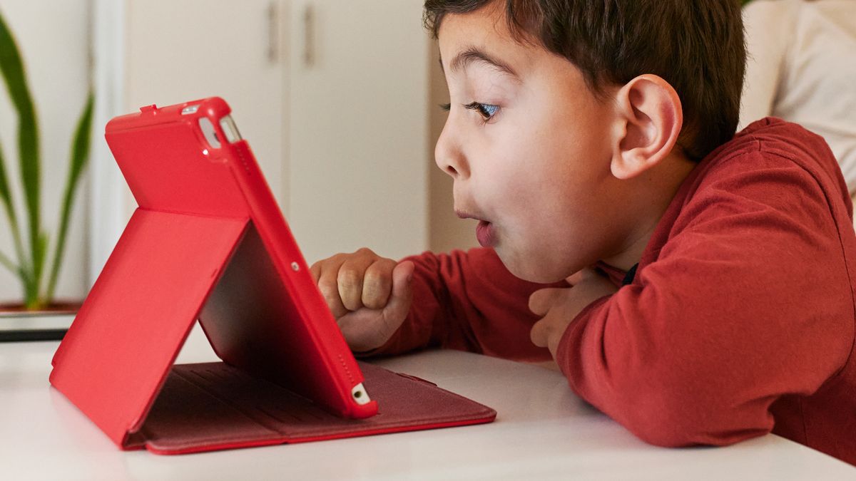 kid playing with tablet in red case