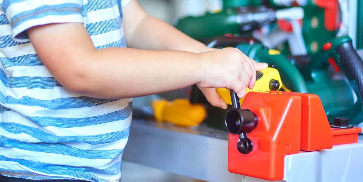 toddler playing with toy work bench and tools
