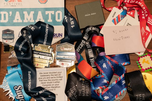 collection of keira d'amato's medals, race bibs and keepsakes