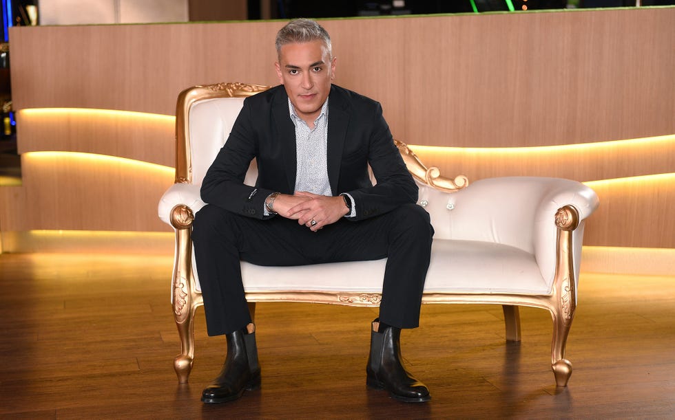 local caption  cuerpo entero  sentado  con traje negro de marciano  gente con estilo