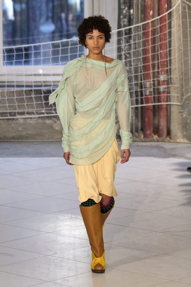 a person wearing a green shirt and yellow shorts