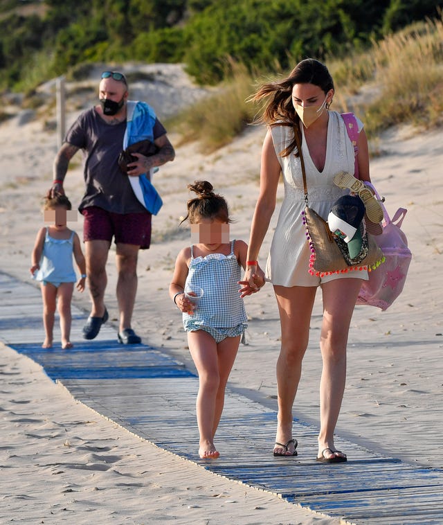 el hijo de isabel pantoja y su mujer llevan de la mano a sus niñas en una pasarela de una playa de cádiz
