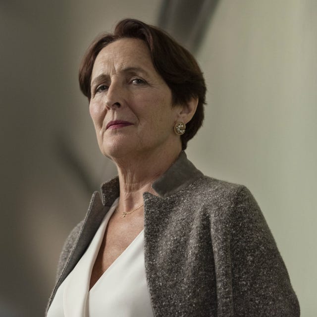 a woman wearing a stylish grey jacket and white top