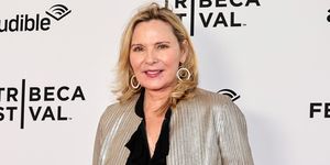 kim cattrall wearing a black blouse and metallic blazer, smiling on the red carpet at the 2023 tribeca festival