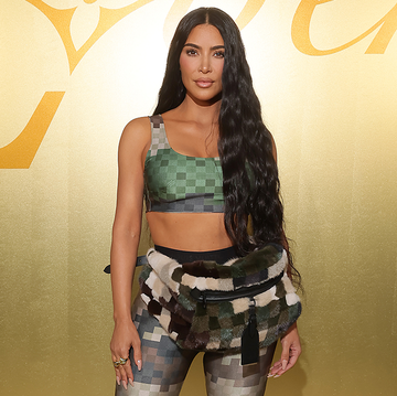 kim kardashian at the louis vuitton ss24 pfw menswear show wearing a crop top, leggings, and bum bag