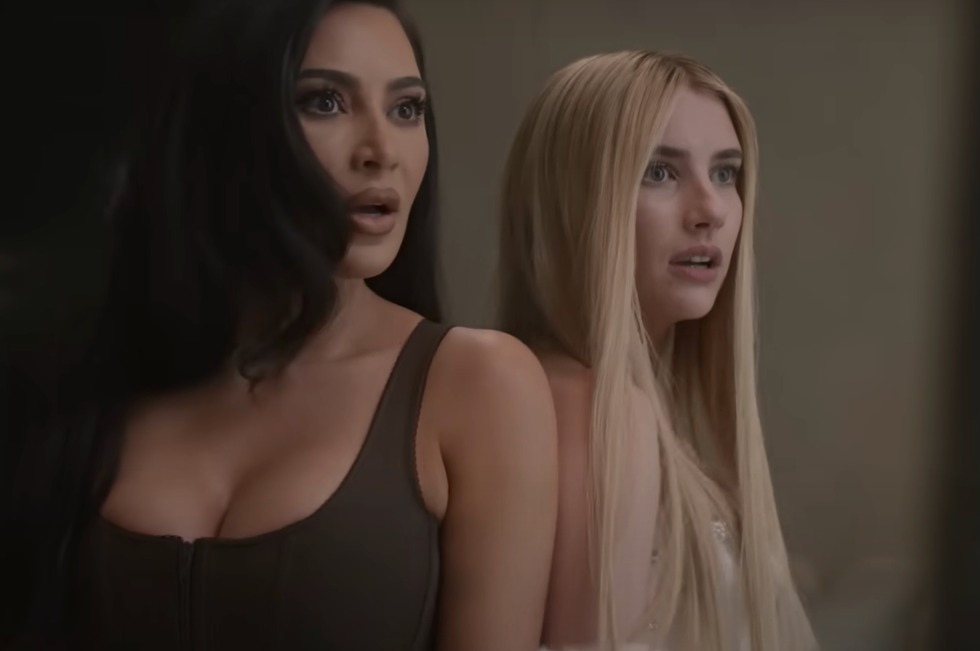 kim kardashian and emma roberts standing shoulder to shoulder with shocked expressions on their faces in a scene for american horror story delicate