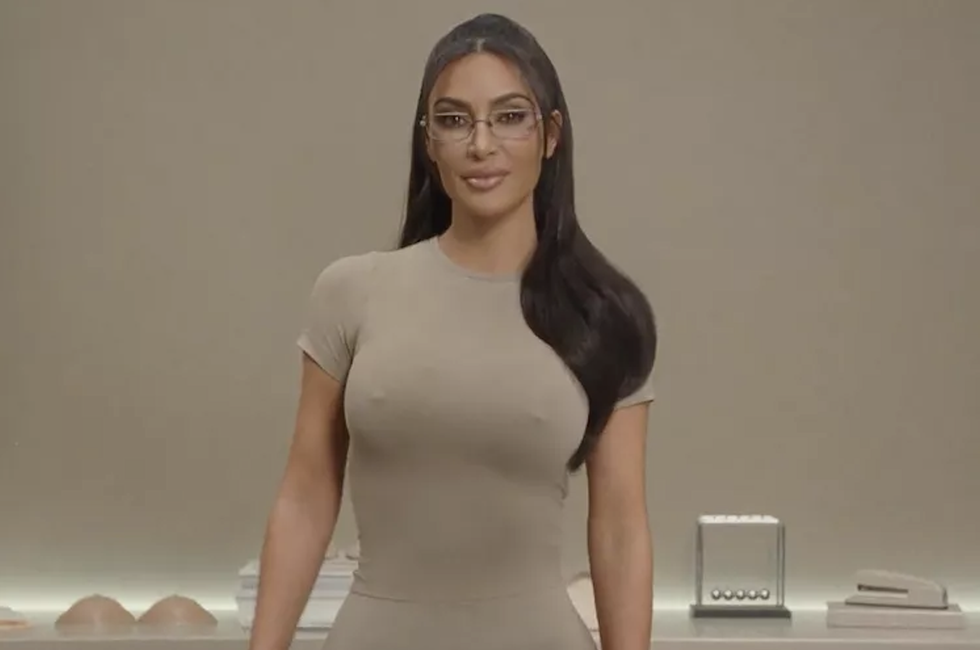a woman wearing glasses in a beige outfit