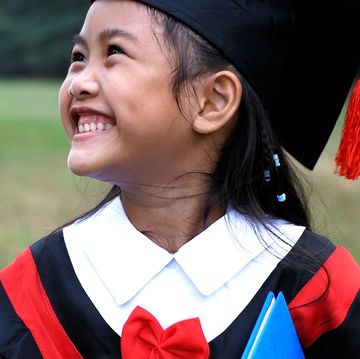 young child smiling in graduation cap and gown