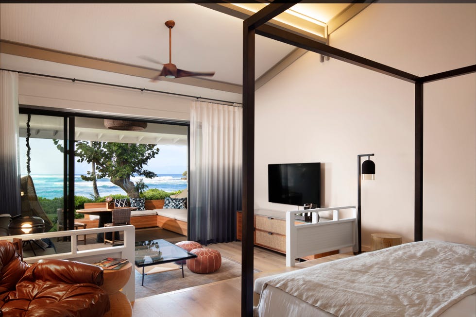 beach front hotel room with large open window and palm trees in the background