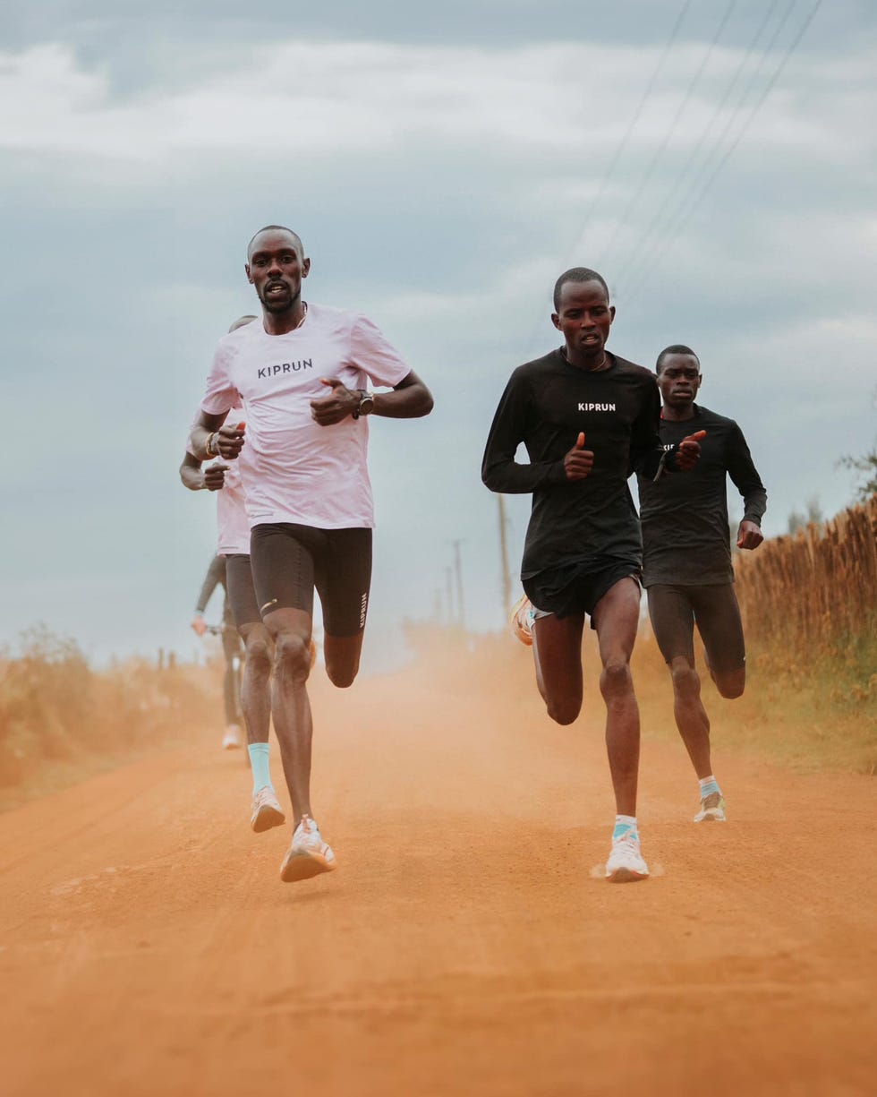 a group of men running on a dirt road