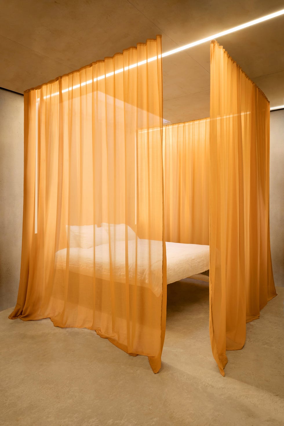 amber coloured sheer curtains around a bed