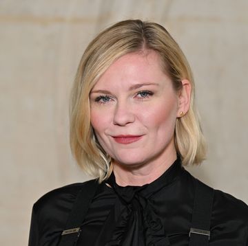 kirsten dunst wearing a black dress and looking straight ahead for a portrait photo