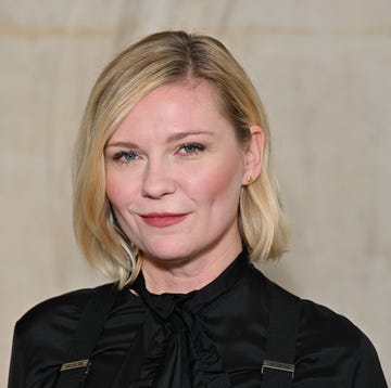 kirsten dunst wearing a black dress and looking straight ahead for a portrait photo