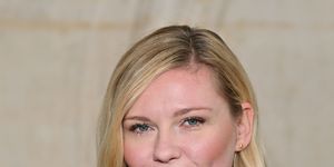 kirsten dunst wearing a black dress and looking straight ahead for a portrait photo