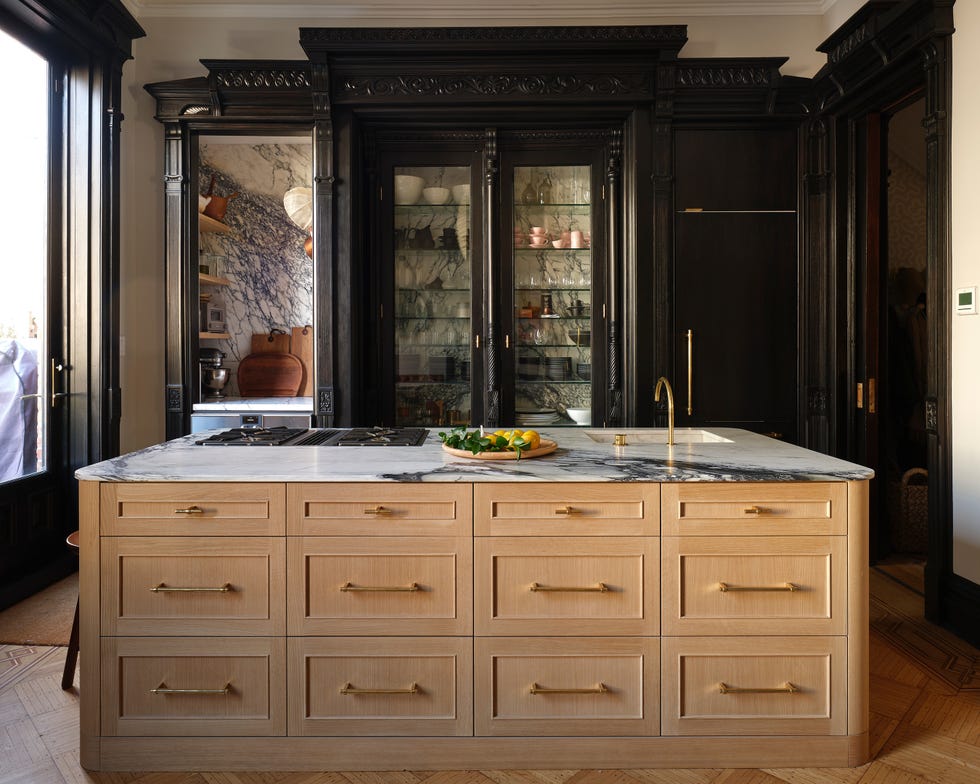 modern kitchen with a marbletopped island and a dark wood backdrop