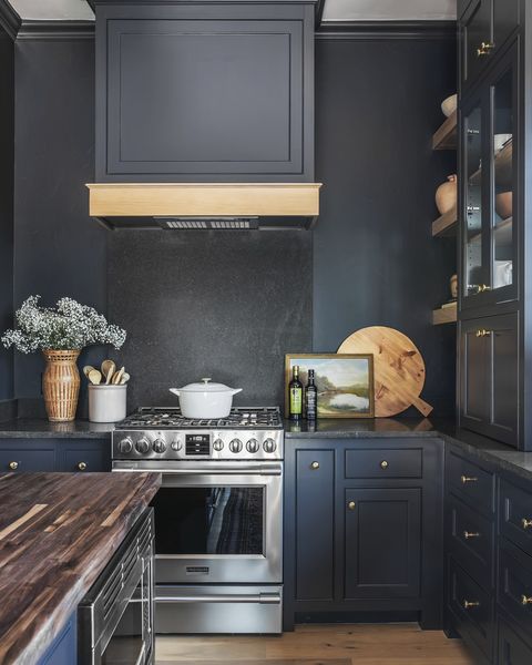 oklahoma designer kelsey leigh
mcgregor used charcoal gray
negresco granite on the backsplash
and countertops of this kitchen so
they would nearly disappear against
the dark paint paint after midnight,
kelly moore paints range frigidaire
professional art vintage