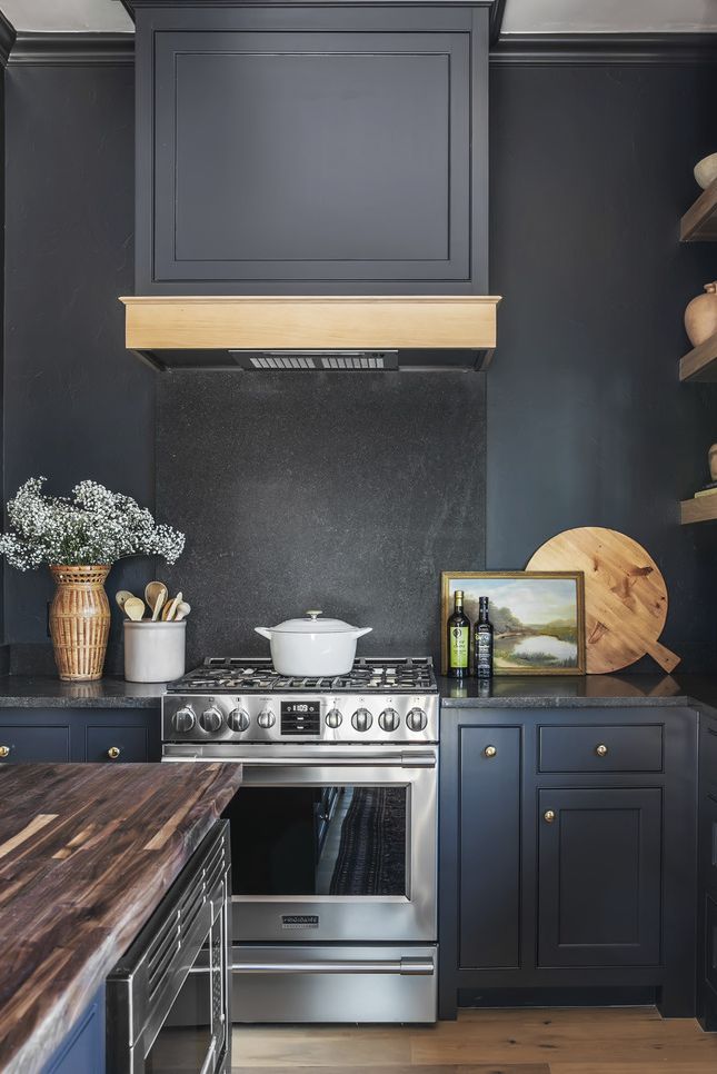 oklahoma designer kelsey leigh
mcgregor used charcoal gray
negresco granite on the backsplash
and countertops of this kitchen so
they would nearly disappear against
the dark paint paint after midnight,
kelly moore paints range frigidaire
professional art vintage