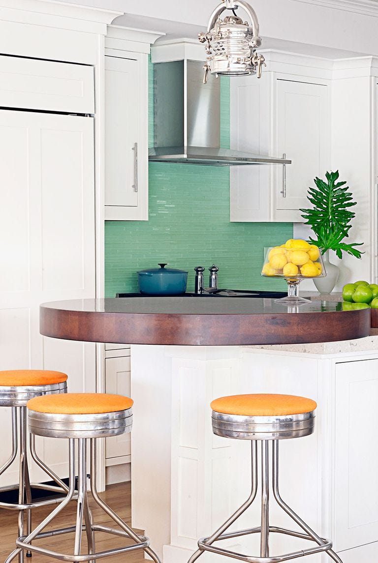 kitchen backsplash ideas, mint green backsplash in the kitchen with an island and retro bar stools with orange cushions