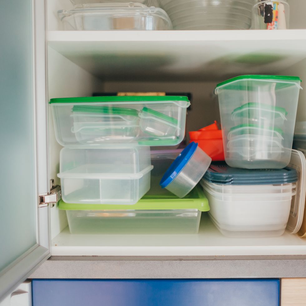 kitchen cabinet full of food plastic containers and lunch boxes