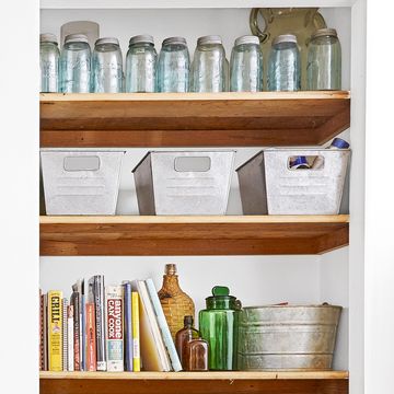 wood cabinet shelves with baskets and jars and kitchen items arranged neatly