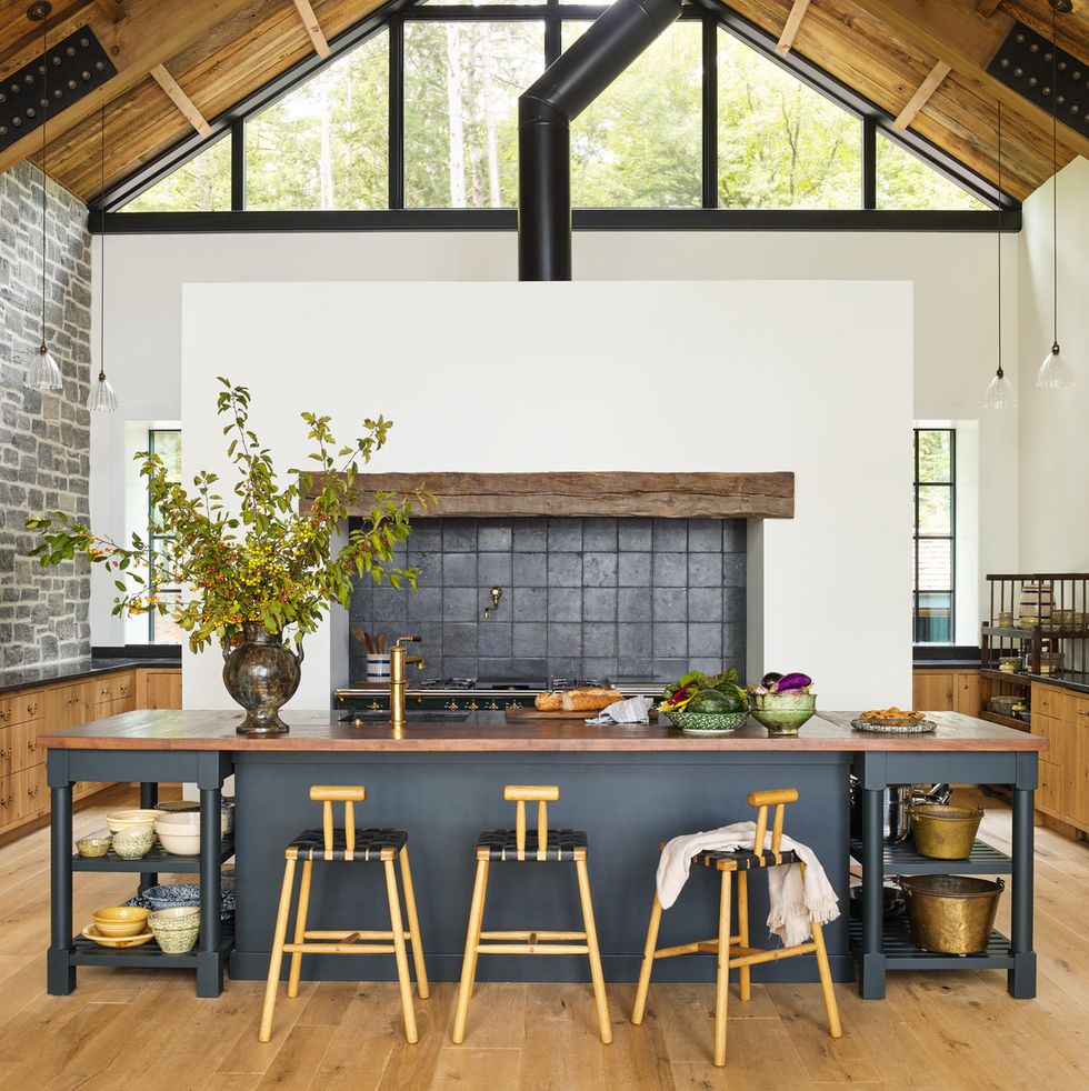 michigan lake house designed by amy meier of california based amy meier design the deep green kitchen island is painted salamander by benjamin moore belgium blue stone tiles, country floors stools, bicyclette