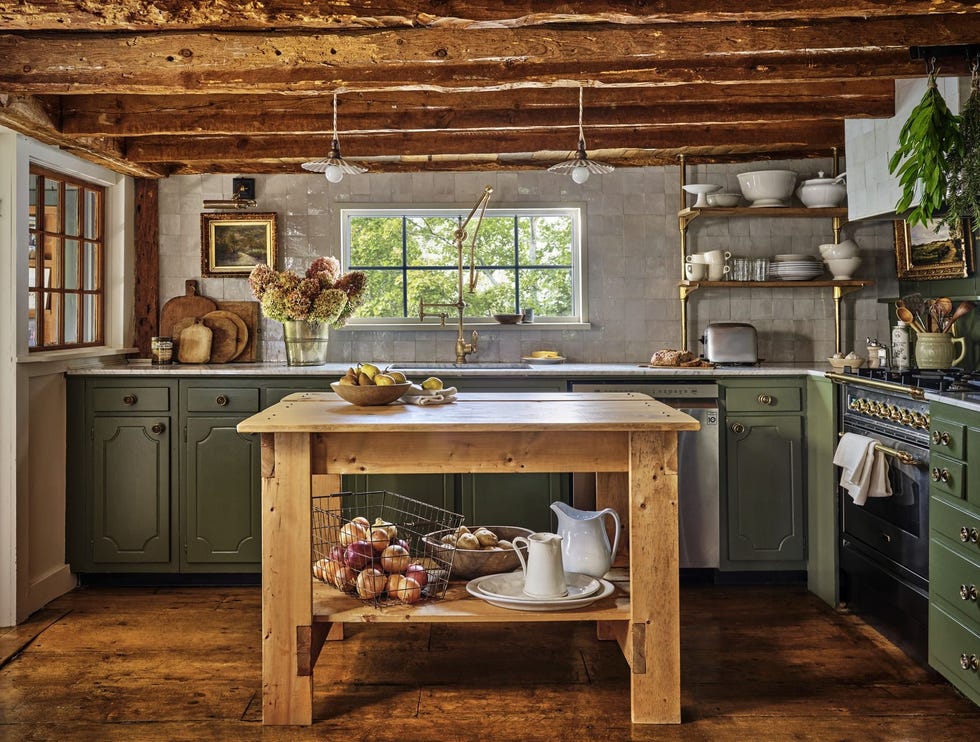 muted green kitchen cabinets in rustic cape cod home with rough hewn ceiling beams