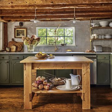 muted green kitchen cabinets in rustic cape cod home with rough hewn ceiling beams