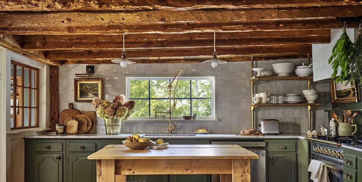 muted green kitchen cabinets in rustic cape cod home with rough hewn ceiling beams
