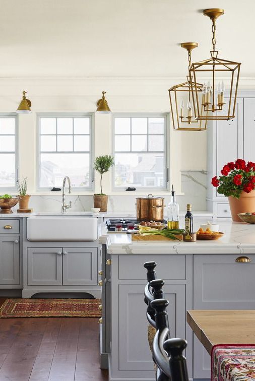 4 drilled holes form points of diamond in upper doors, illustrating decorative cutout kitchen cabinet trend, in new england kitchen designed by katie rosenfeld with cabinets and island painted silver lining by benjamin moore