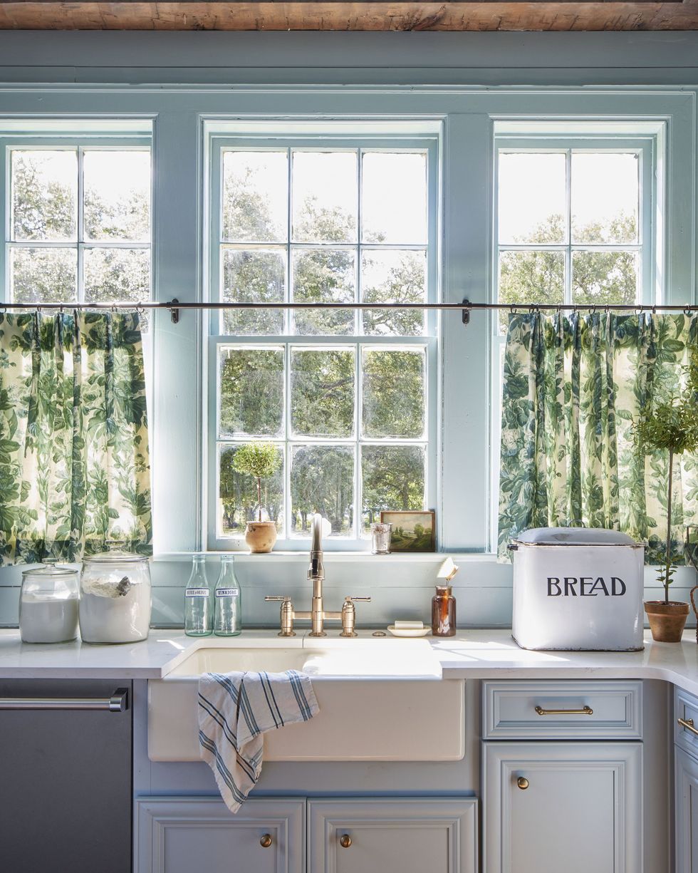pale blue kitchen cabinets with on trend unlacquered hardware in farmhouse in 10 acre pecan grove in the mississippi delta designed by holly audrey williams and rachel hardage barrett