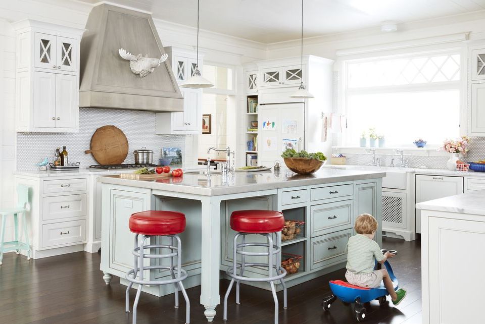 white kitchen with light blue island and red barstools