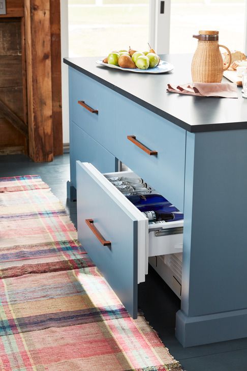 gray blue kitchen island with refrigerator drawer open to reveal drinks inside, next to colorful plaid rug