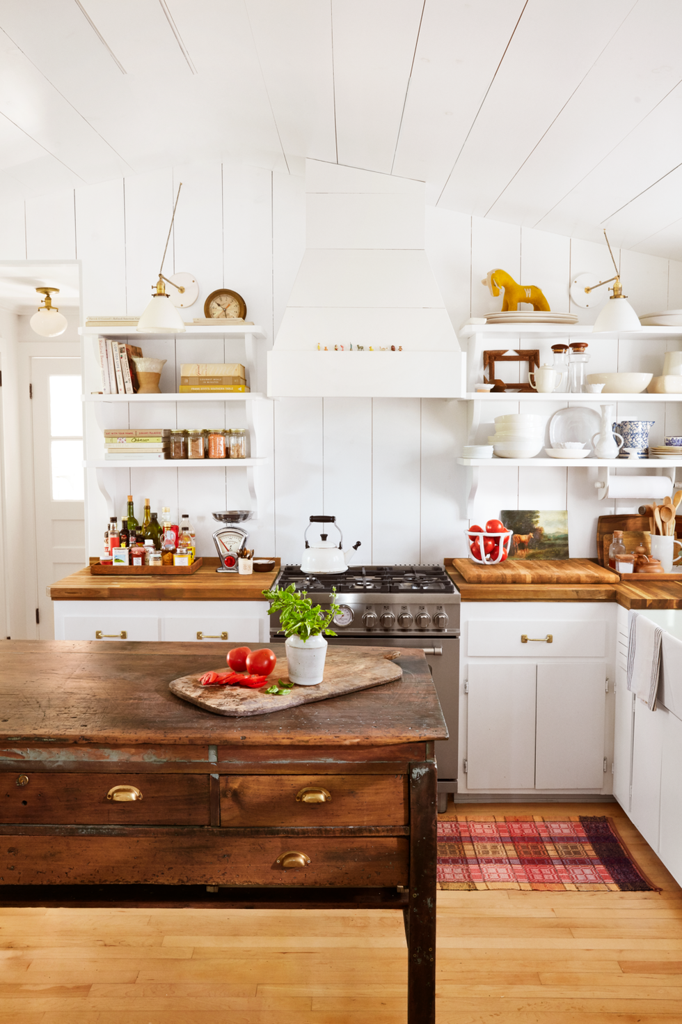 old wood printing press worktable repurposed as unique kitchen island in white shiplap kitchen with butcher block counters