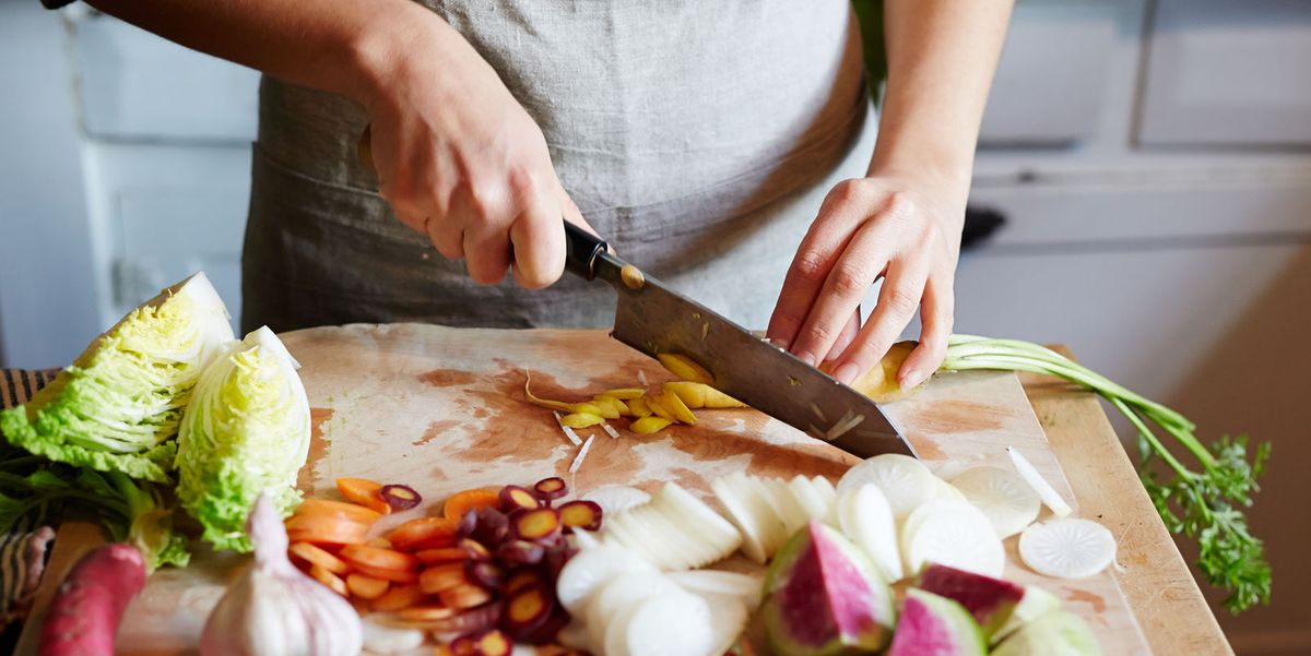 person chopping vegetables with kitchen knife