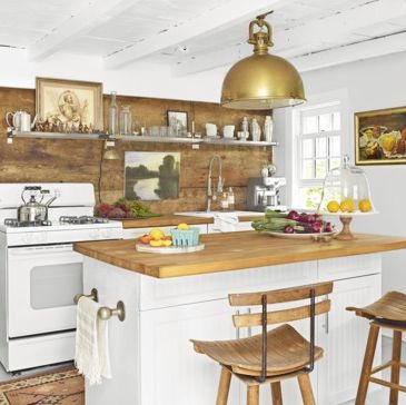 a white and wood kitchen with a large brass pendant