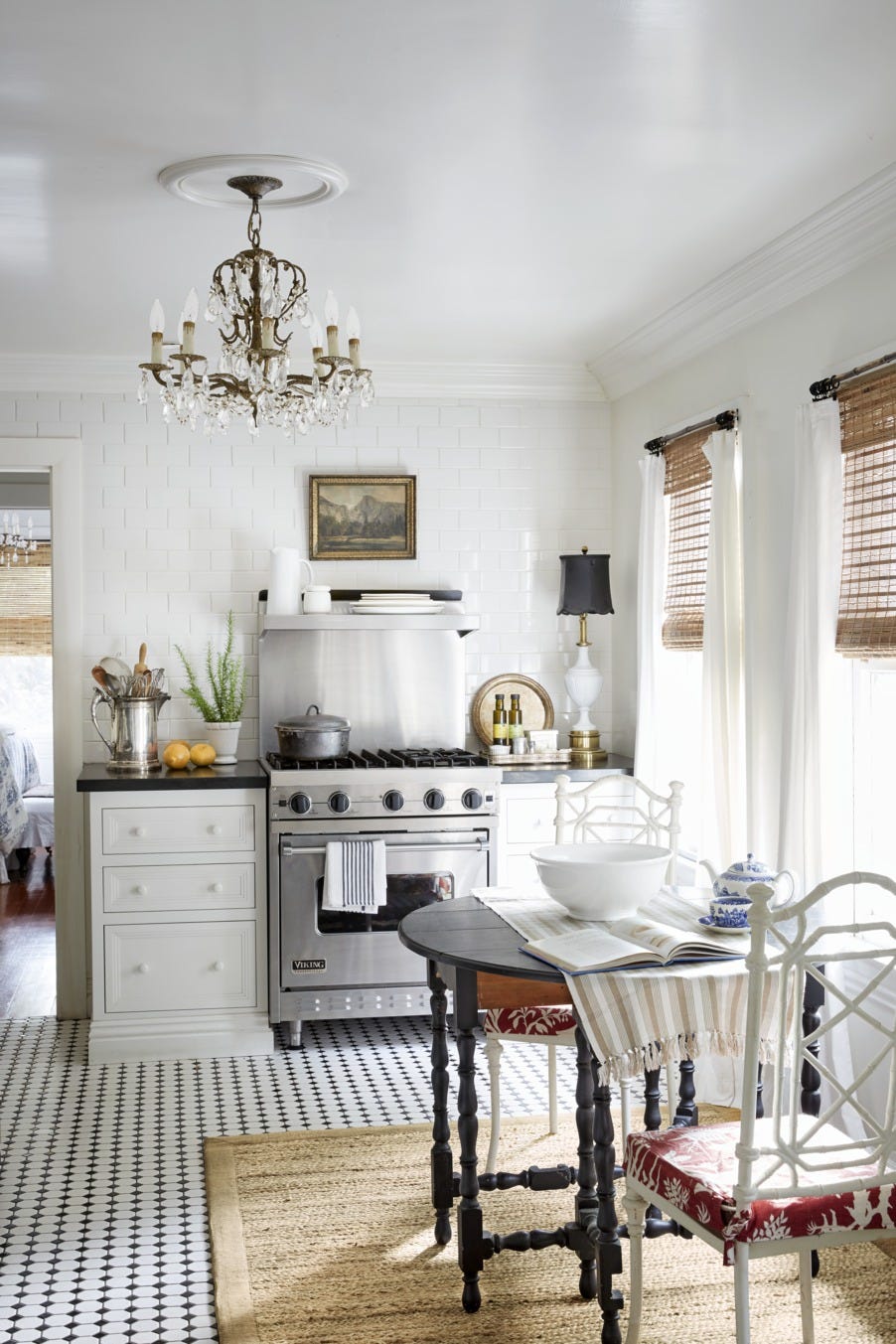 crystal chandelier and a tall slender table lamp nestled into the corner give this kitchen an elegant feel thats in keeping with the rest of the house