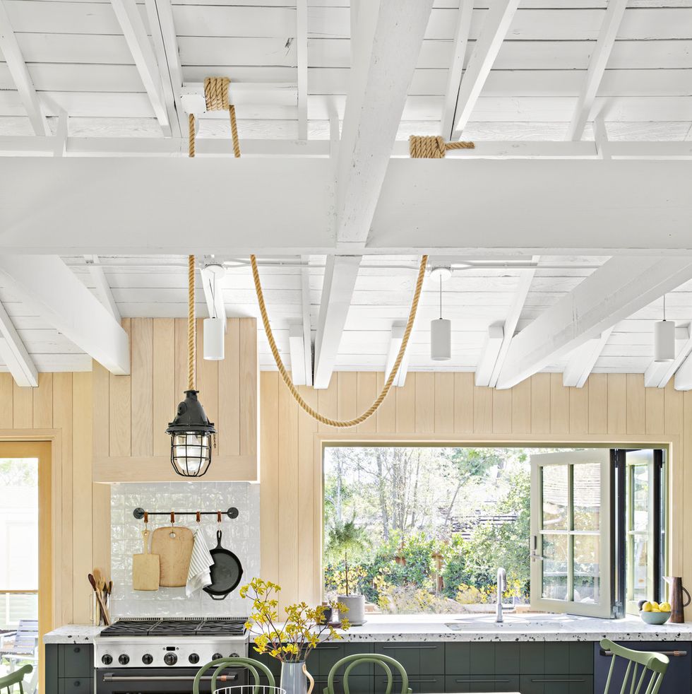 the outdoorsy type southern california cottage kitchen with dark green cabinets and wood paneled walls