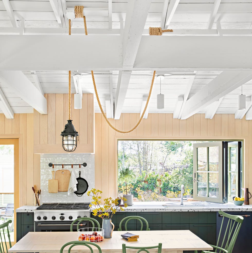 the outdoorsy type southern california cottage kitchen with dark green cabinets and wood paneled walls