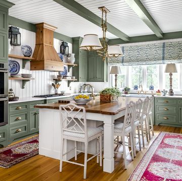 kitchen with soothing green painted cabinets, rafters, and trim paired with white paneled walls, ceiling, and island