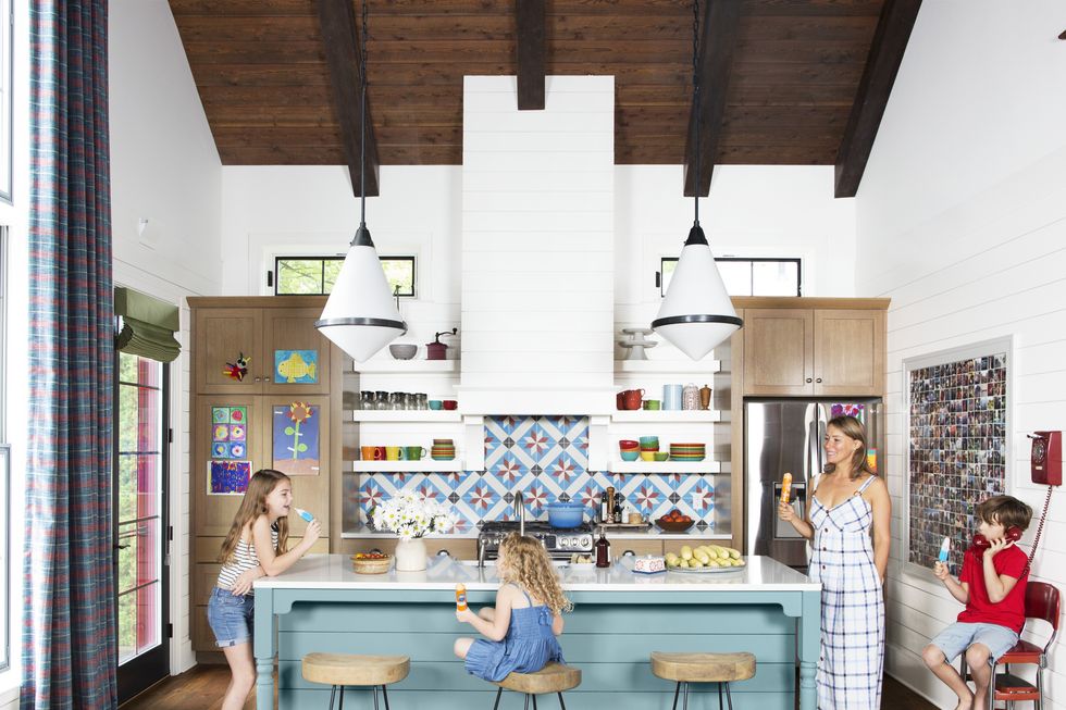 colorful lake house kitchen with white walls, wood toned cabinets, island painted a watery blue color
