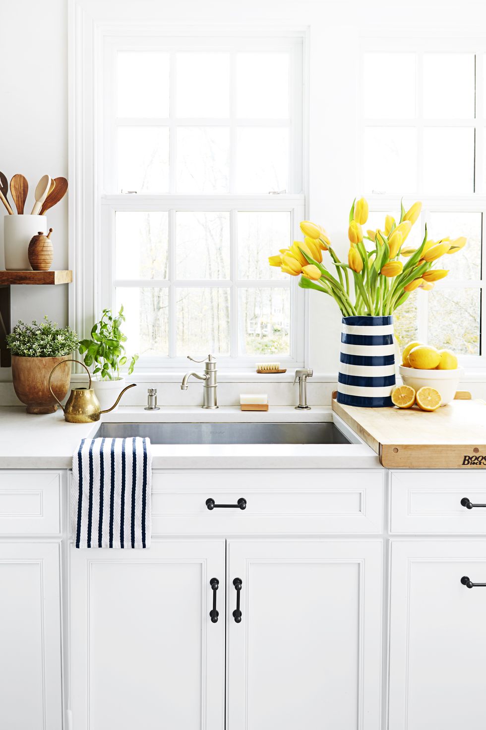 stainless steel kitchen sink with white counters yellow flowers and lemons