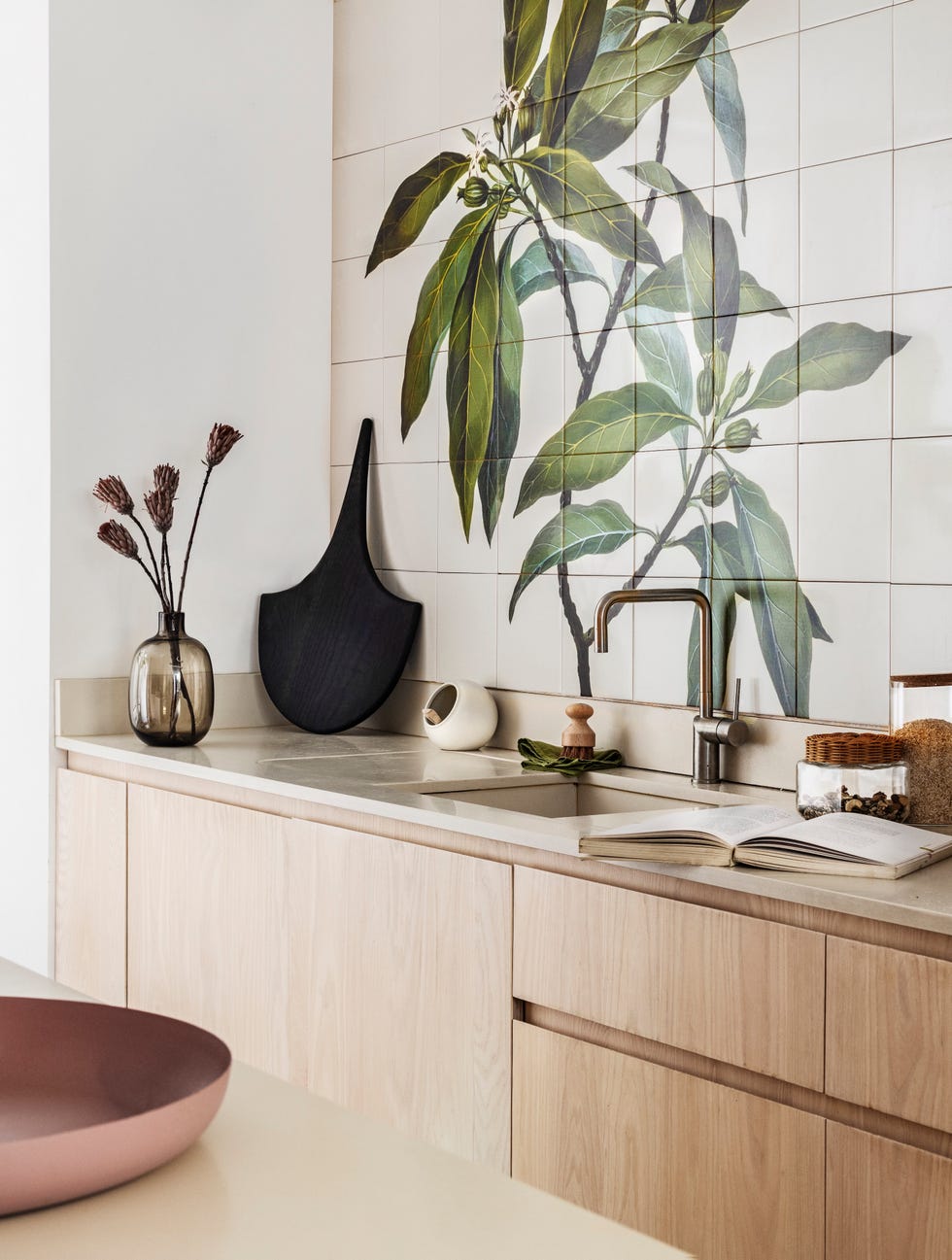 white kitchen wall tiles with a green botanical mural design and wooden units