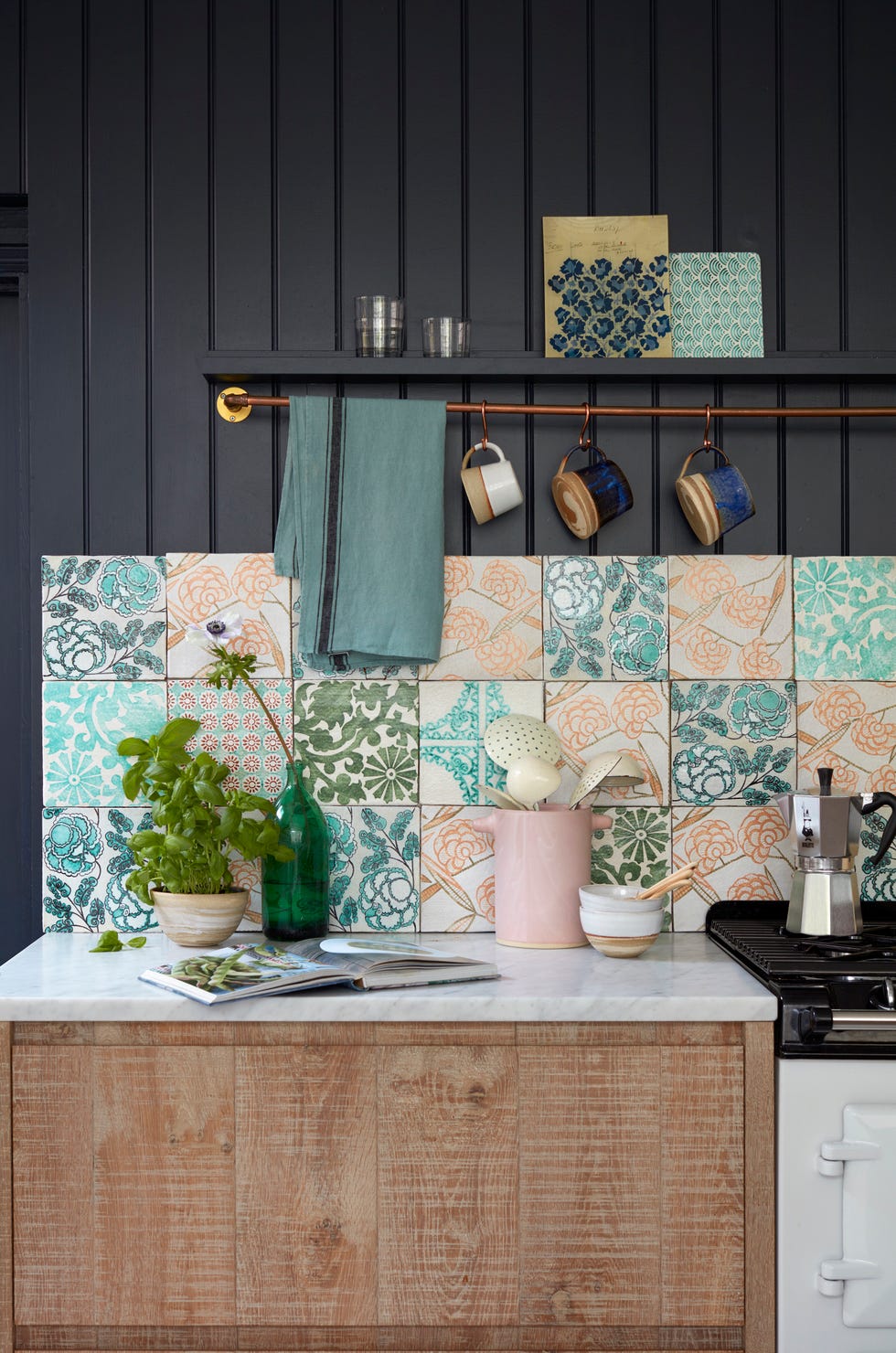 a dark grey panelled kitchen with eclectic floral patterned wall tiles