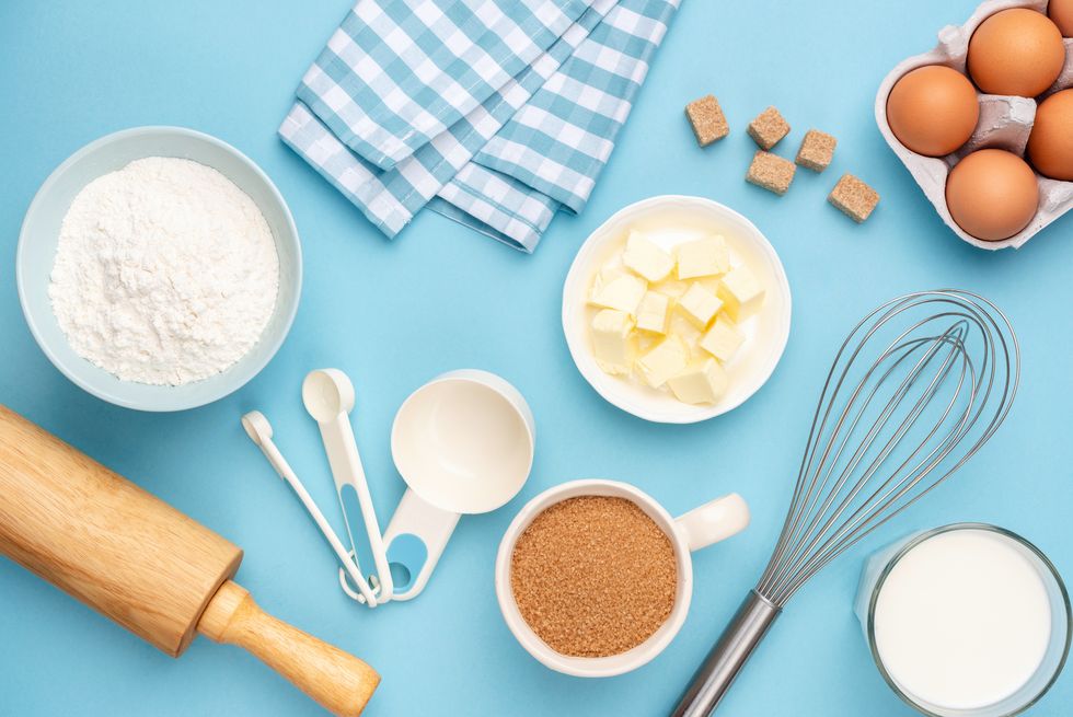 kitchen utensils and baking ingredients on blue background