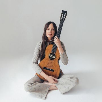 a person sitting on the floor holding a guitar
