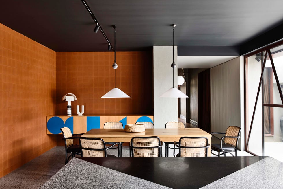 contemporary dining room with terracotta wall tile and graphic blue wood cabinet with cantilever chairs around dining table