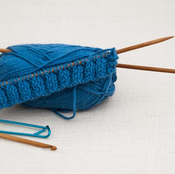 knitting wool yarn and knitting needles on white linen background